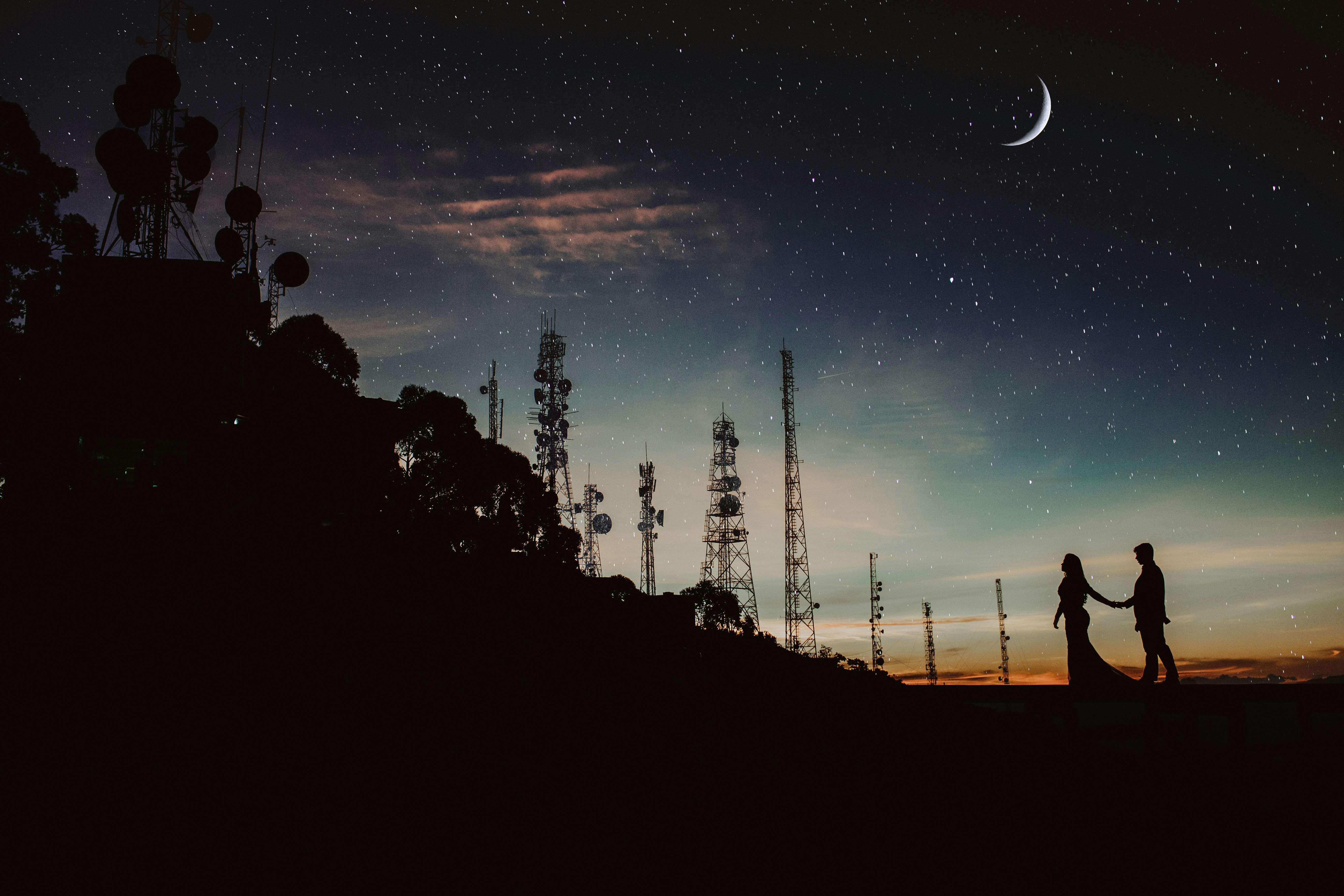 silhouette of two person under half-mooon